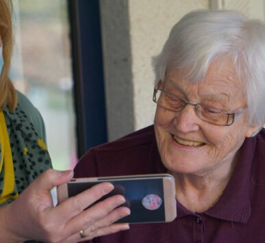 woman in brown button up shirt holding white smartphone